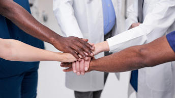 Group of diverse medical professionals putting their hands out
